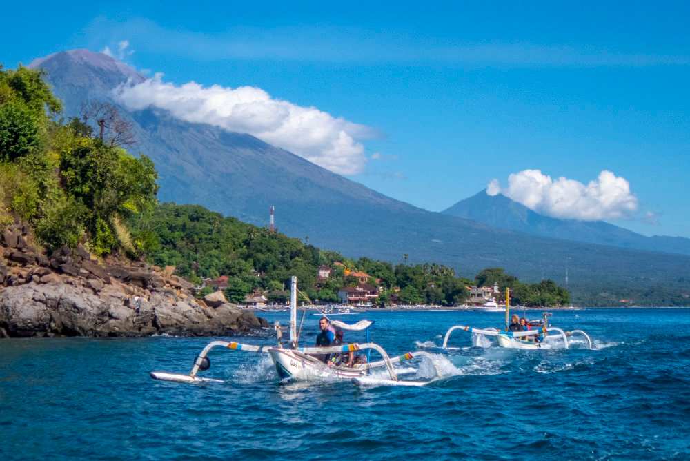Traditional jukung outrigger boats in Amed with Mount Agung behind